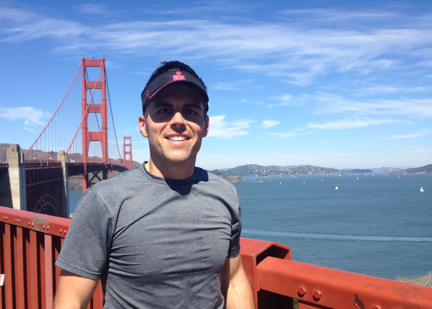 Chad Kempel smiling on the Golden Gate Bridge with San Francisco Bay behind him at the finish of his 100-mile run in 2013