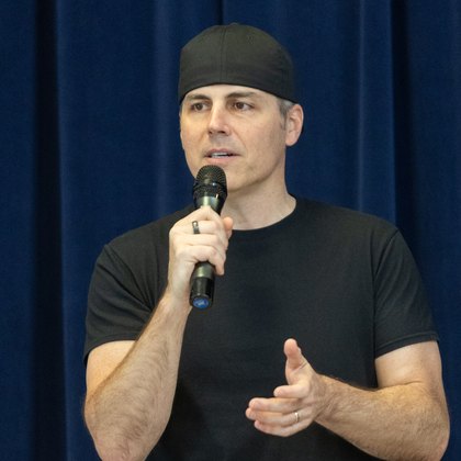 Chad Kempel, motivational speaker, speaking on stage with a microphone