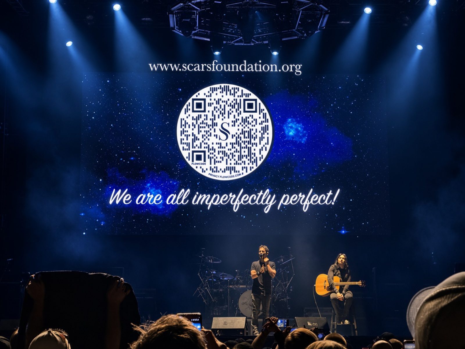 Godsmack on stage under a large screen showing the Scars Foundation website and the words We are all imperfectly perfect