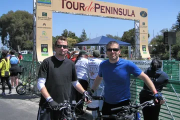 Chad Kempel and his brother with their bikes under the Tour de Peninsula arch in 2010