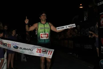 Chad Kempel crossing the Ironman Canada finish line under the 15:18:36 race clock