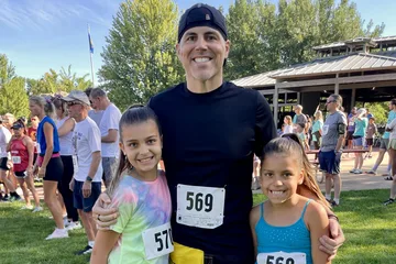 Chad Kempel with his daughters Savannah and Avery, all wearing race bibs, before Eagle Fun Days