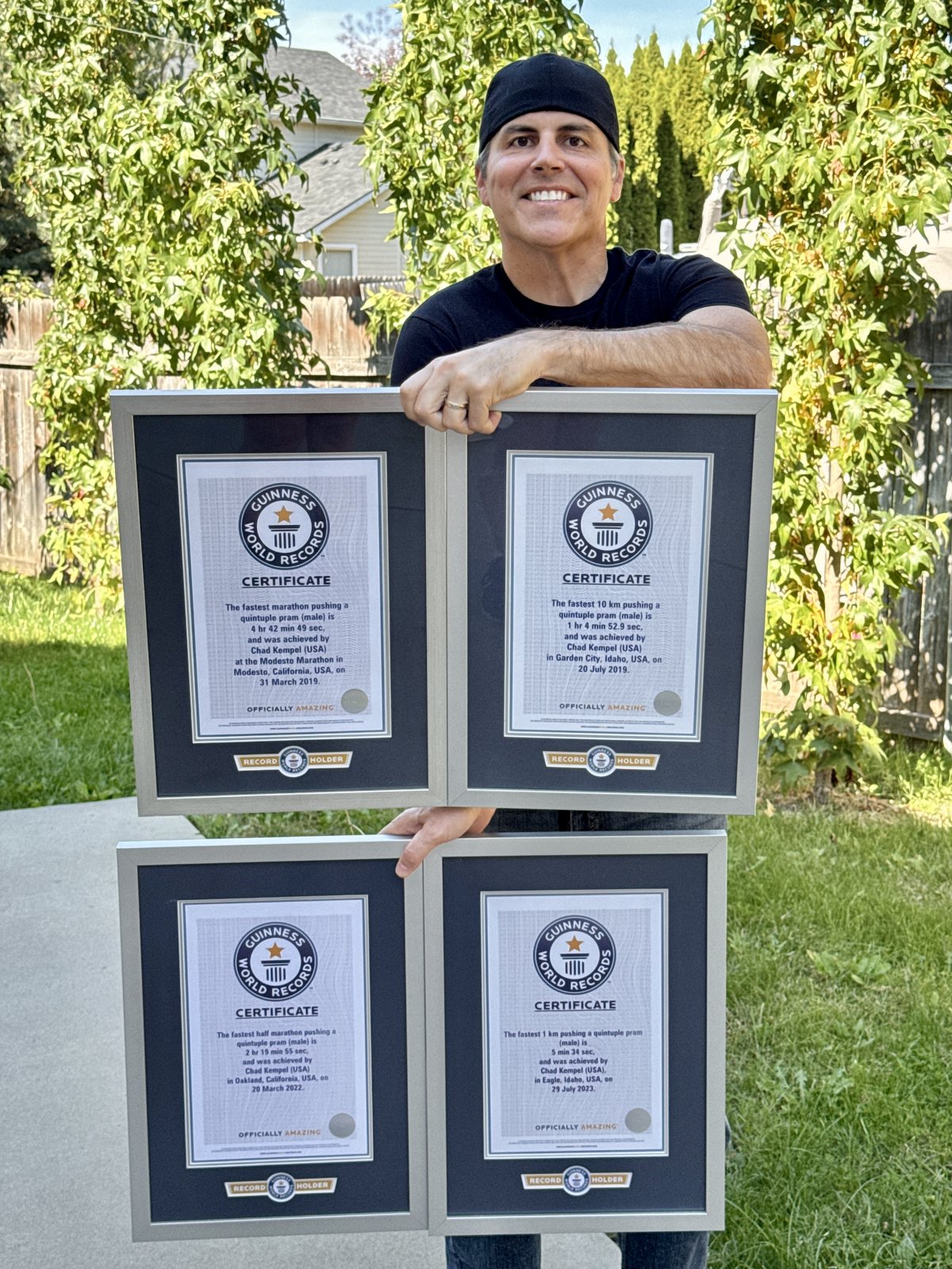 Chad Kempel holding four Guinness World Records certificates, stacked